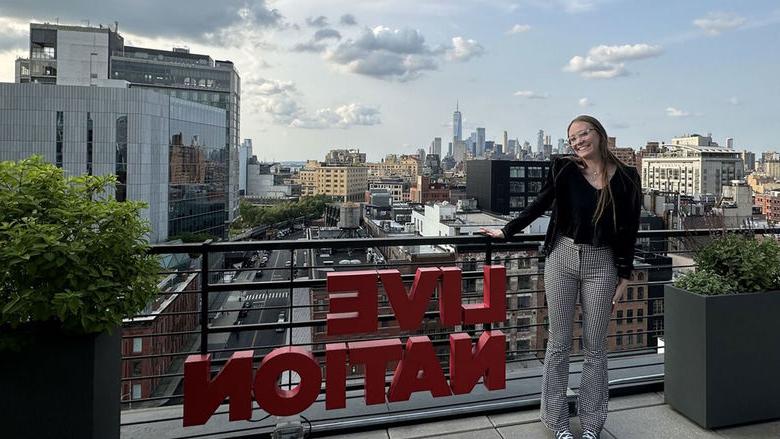 Woman standing on rooftop next to a Live Nation sign